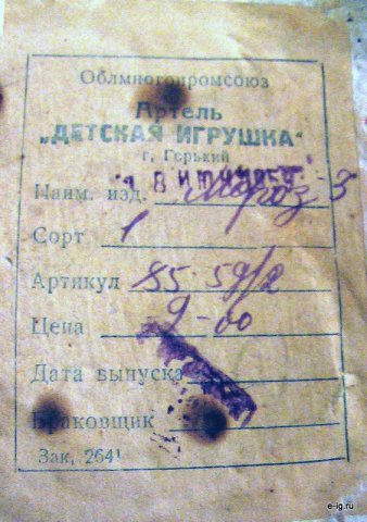 Пожелтевший бумажный ярлык Деда Мороза с синей печатью и рукописными пометками.